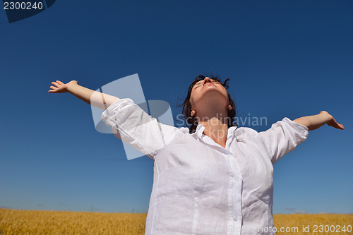 Image of young woman in wheat field at summer