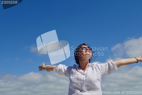 Image of young woman with spreading arms to sky