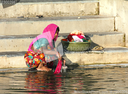 Image of Indian woman washing clothes in the lake