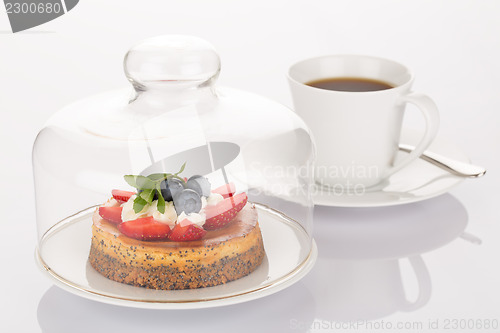 Image of Cheesecake, glass bell and cup of coffee