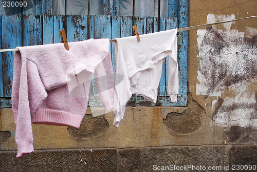 Image of Sweater and shirt on a clothes line