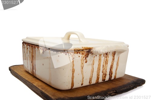 Image of Dirty ceramic pot for stove on old kitchen board