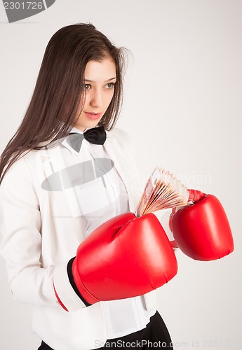 Image of young businesswoman in boxing gloves