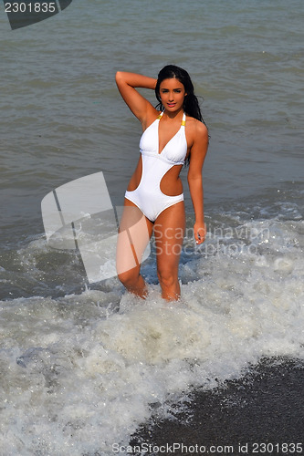 Image of Bikini girl standing in wave.