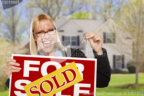 Image of Woman with Sold Sign and Keys in Front of House