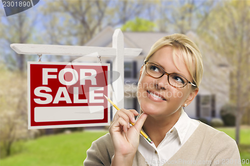 Image of Young Woman in Front of Sold Sign and House