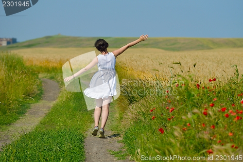 Image of young woman in wheat field at summer