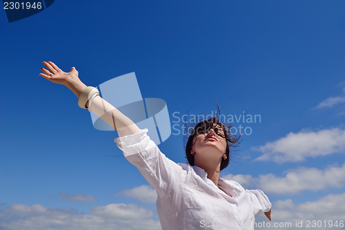 Image of young woman with spreading arms to sky