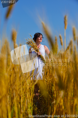 Image of young woman in wheat field at summer