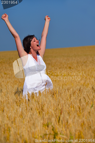 Image of young woman in wheat field at summer