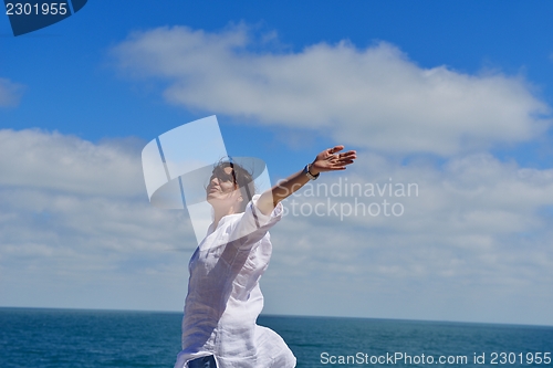 Image of young woman with spreading arms to sky