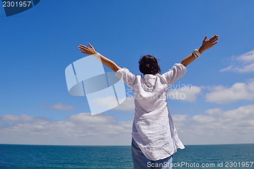 Image of young woman with spreading arms to sky