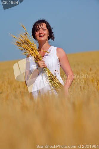 Image of young woman in wheat field at summer