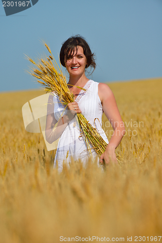 Image of young woman in wheat field at summer