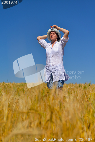 Image of young woman in wheat field at summer