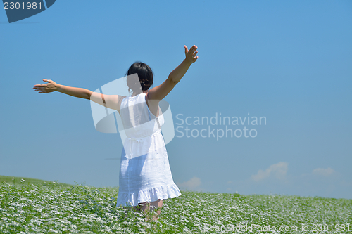 Image of young woman with spreading arms to sky