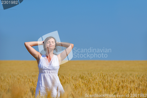 Image of young woman in wheat field at summer