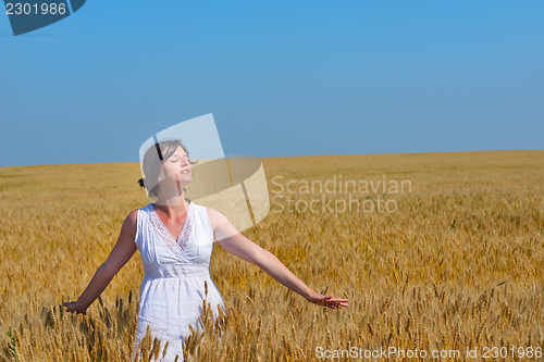 Image of young woman in wheat field at summer