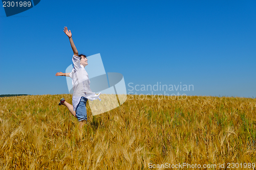 Image of young woman in wheat field at summer