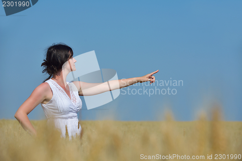 Image of young woman in wheat field at summer