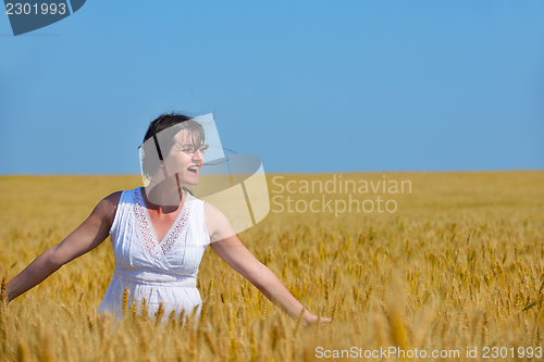 Image of young woman in wheat field at summer