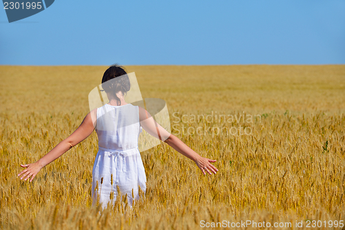 Image of young woman in wheat field at summer
