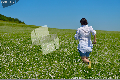 Image of Young happy woman in green field