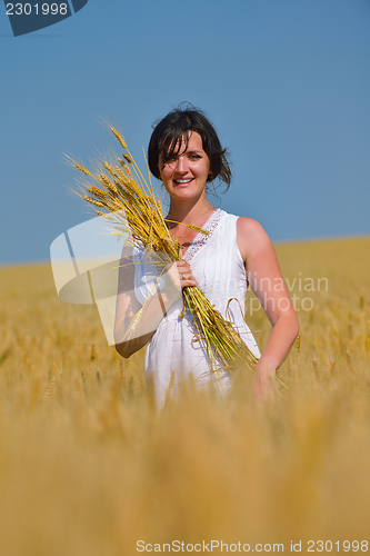 Image of young woman in wheat field at summer