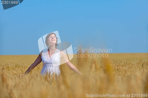 Image of young woman in wheat field at summer