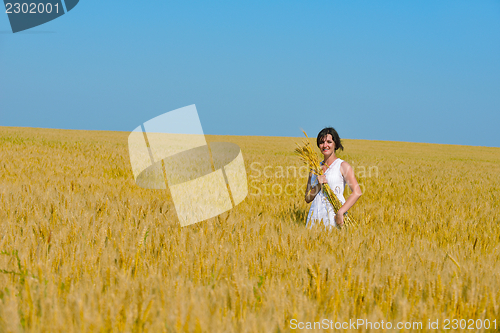 Image of young woman in wheat field at summer