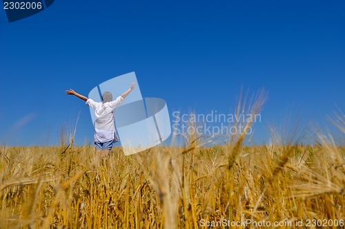 Image of young woman in wheat field at summer