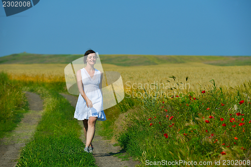 Image of Young happy woman in green field