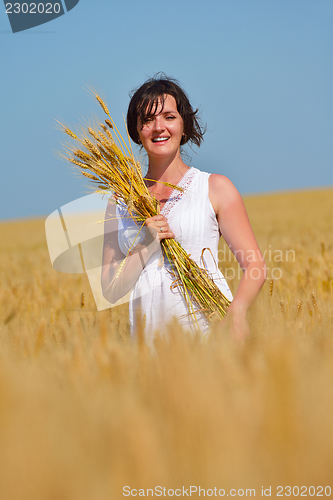 Image of young woman in wheat field at summer