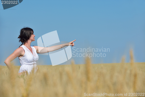 Image of young woman in wheat field at summer