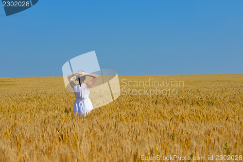 Image of young woman in wheat field at summer