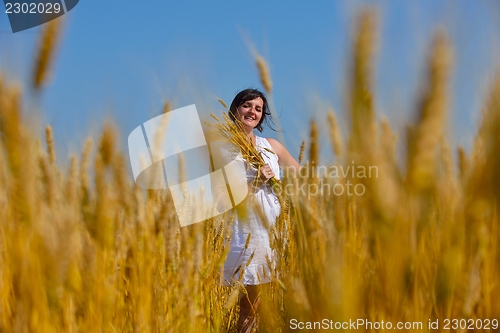 Image of young woman in wheat field at summer
