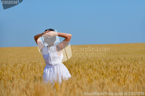 Image of young woman in wheat field at summer