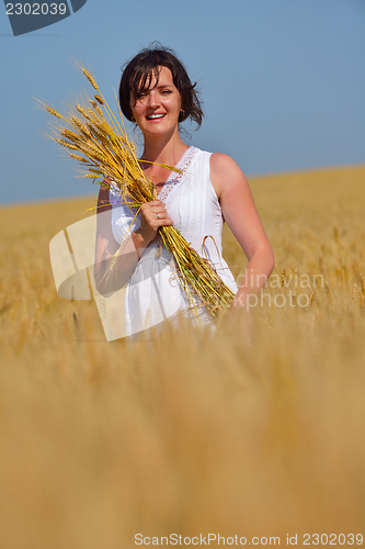 Image of young woman in wheat field at summer
