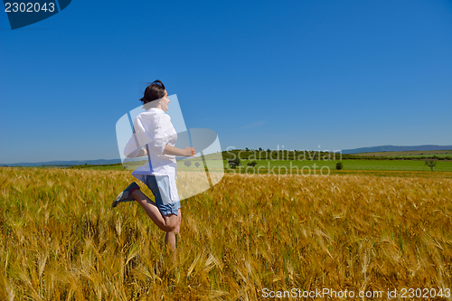 Image of young woman in wheat field at summer