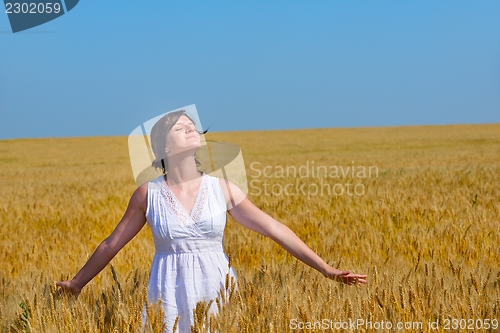 Image of young woman in wheat field at summer