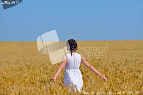 Image of young woman in wheat field at summer