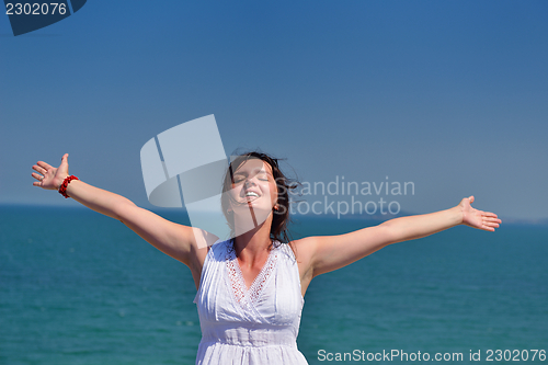 Image of young woman with spreading arms to sky
