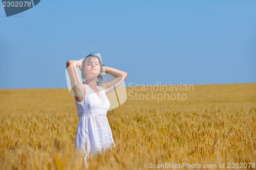Image of young woman in wheat field at summer