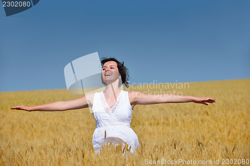 Image of young woman in wheat field at summer