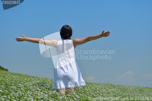 Image of Young happy woman in green field