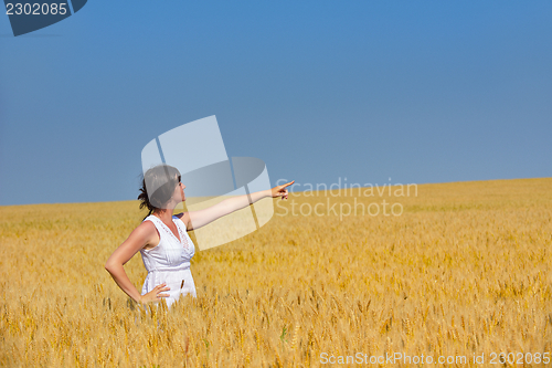 Image of young woman in wheat field at summer
