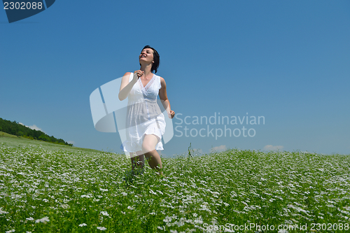 Image of Young happy woman in green field