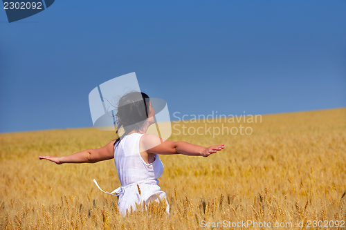 Image of young woman in wheat field at summer