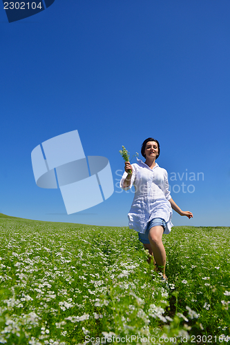 Image of Young happy woman in green field