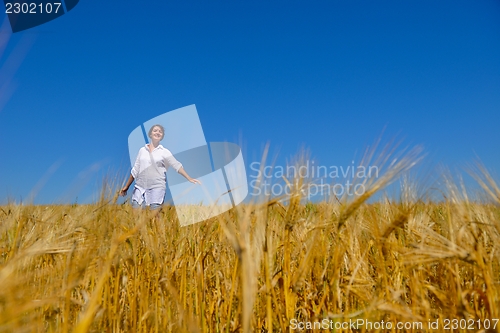 Image of young woman in wheat field at summer